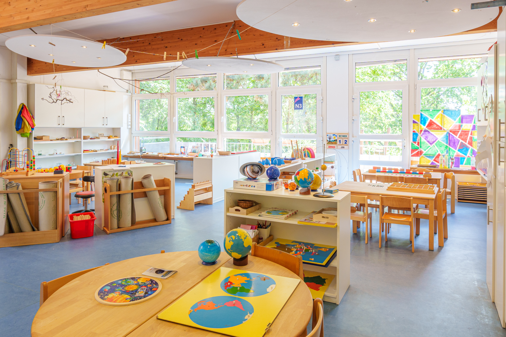 Gruppenraum der Montessori-Gruppe Rot mit kindgerechten Möbeln, Spielmaterialien und heller, freundlicher Raumgestaltung.